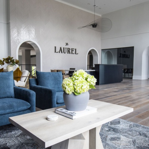 Settle into comfort at The Laurel Apartments  a room with blue chairs and a coffee table