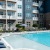 a swimming pool with chairs and umbrellas next to it