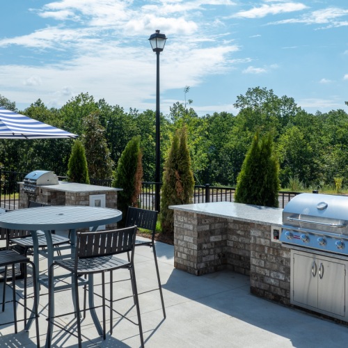 Pool patio and grilling station at The Laurel apartments a patio with tables and chairs outside