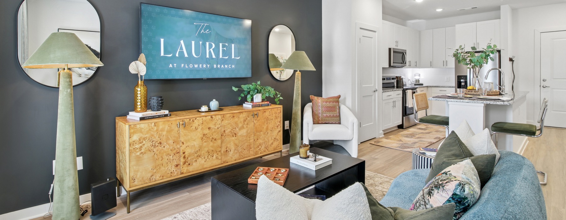 living room with tv, couch, chair, and view of the kitchen with a pantry